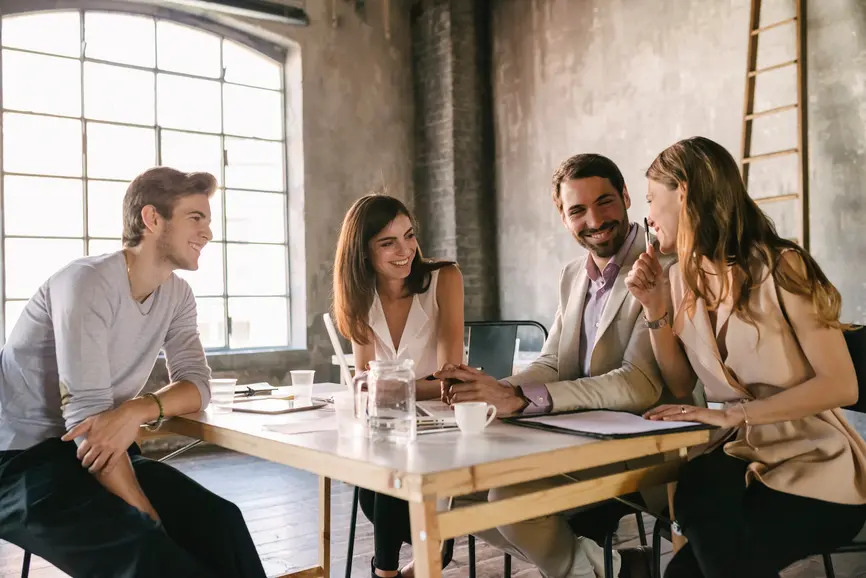 A team of young colleagues sits at a table and talks.