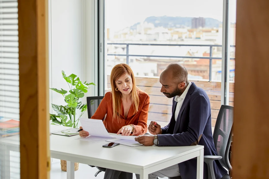 A woman and a man are looking at a document together.