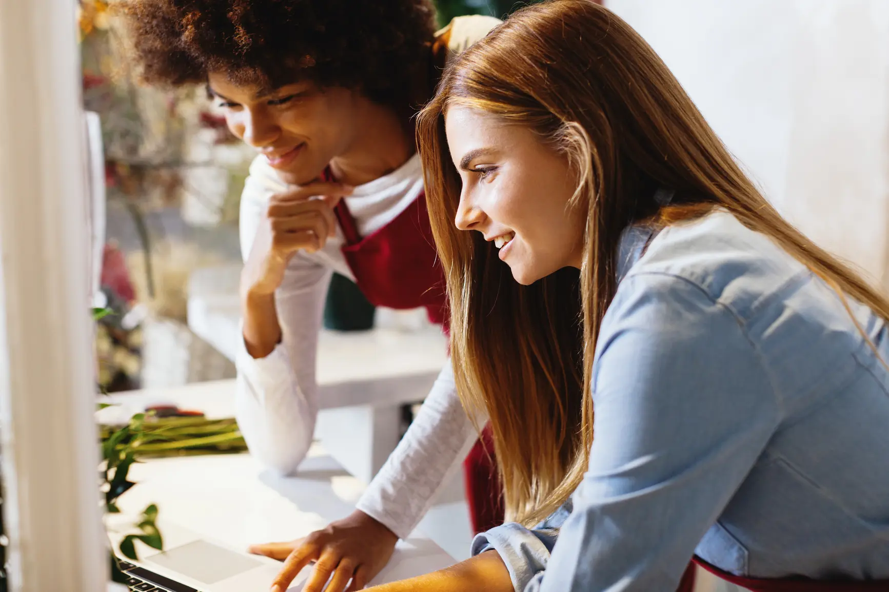 Two women working together on a laptop.