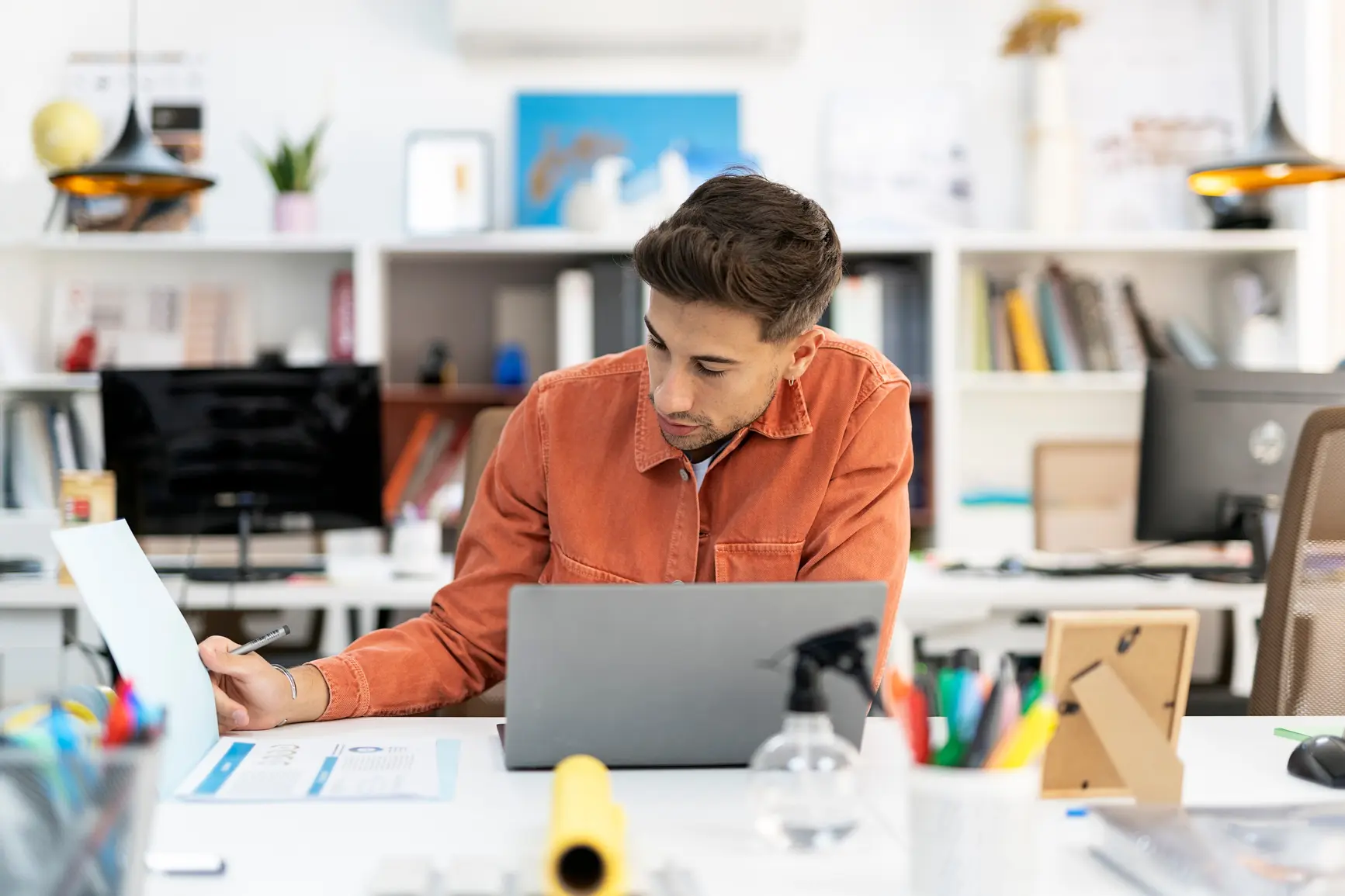 A young man is concentrated at work in a modern and casual office.