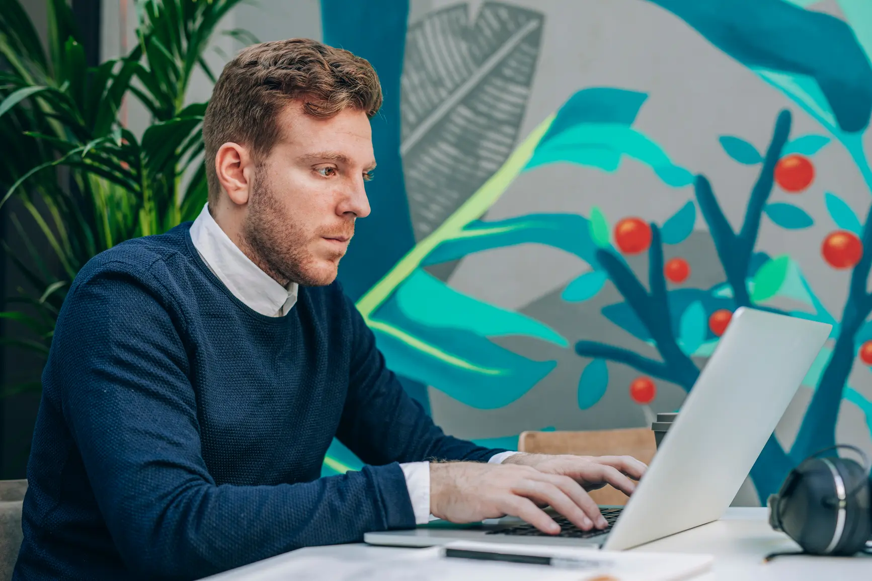 A man in a creatively designed office is typing away at his PC.