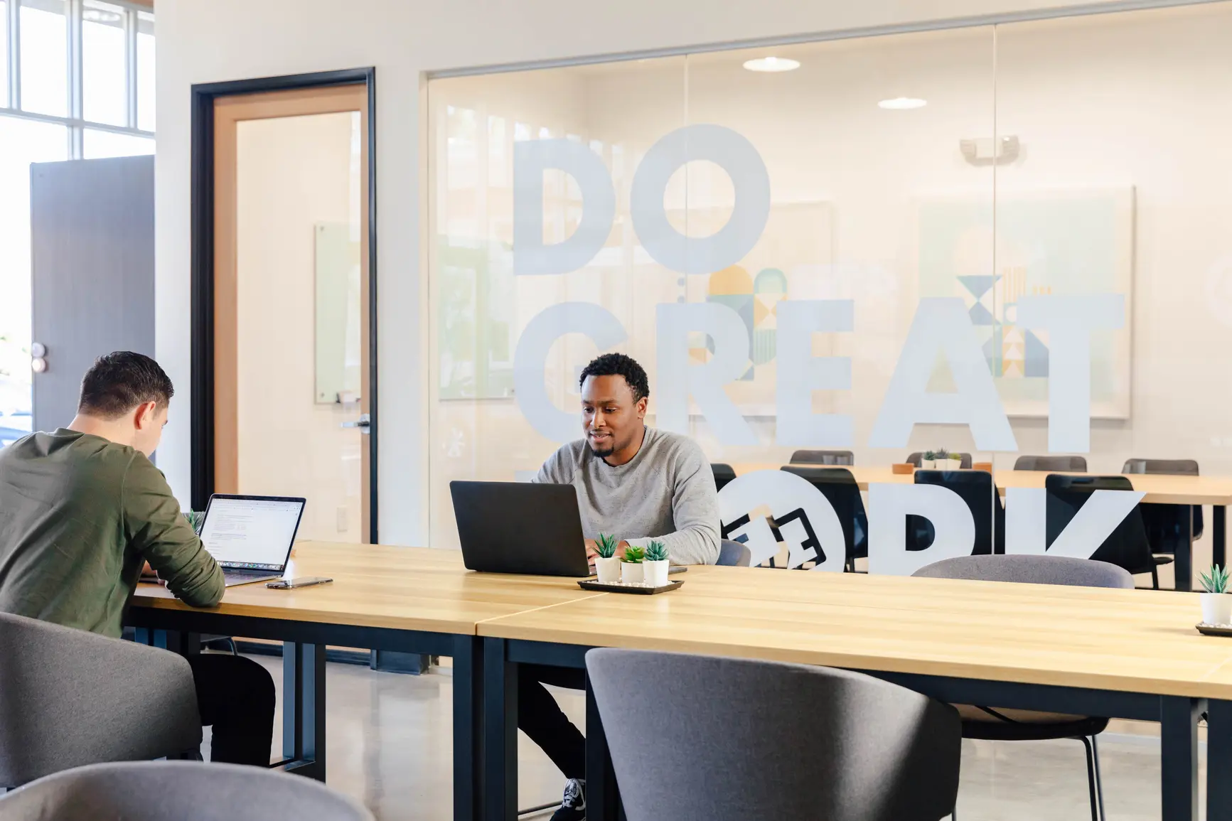 A man in a creatively designed office is typing away at his PC.