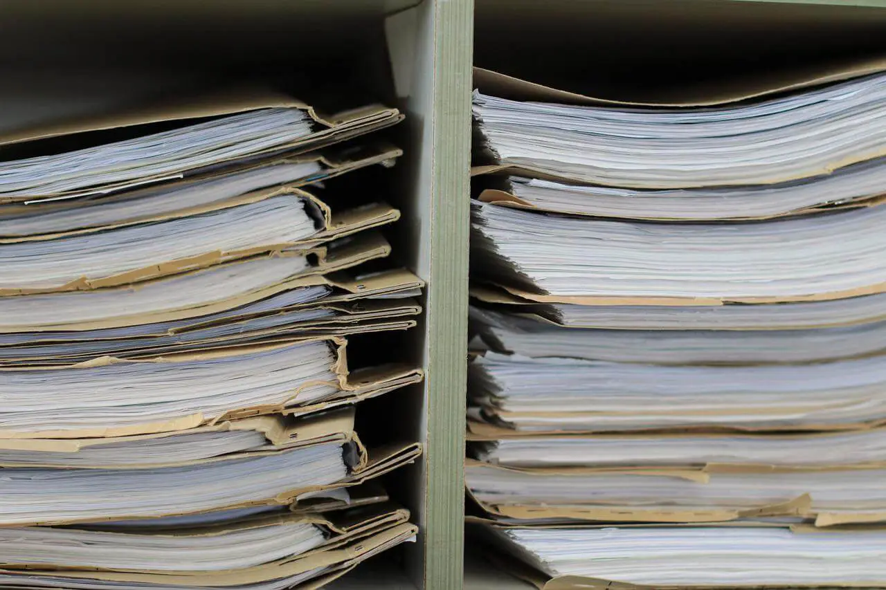 Close-up of several stacks of files on a shelf.