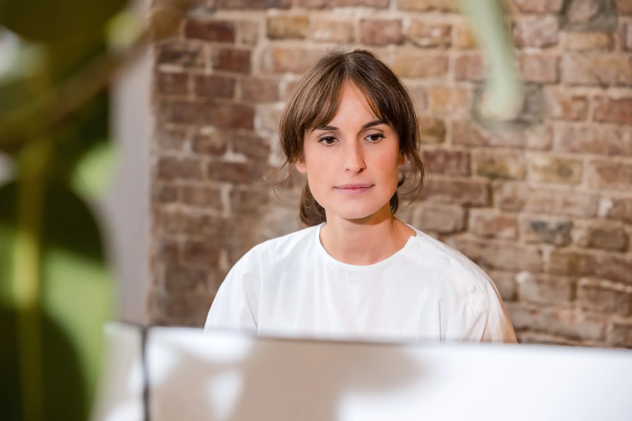 Photo of a young woman looking into her PC.