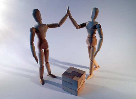 Two wooden figures in human form face each other