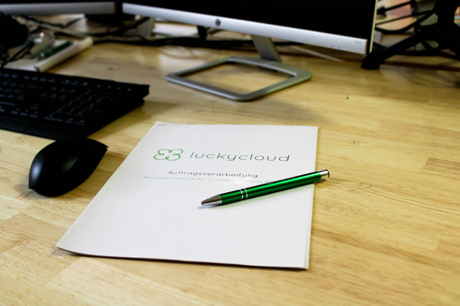 View of a desk on which a folder with luckycloud logo is lying.
