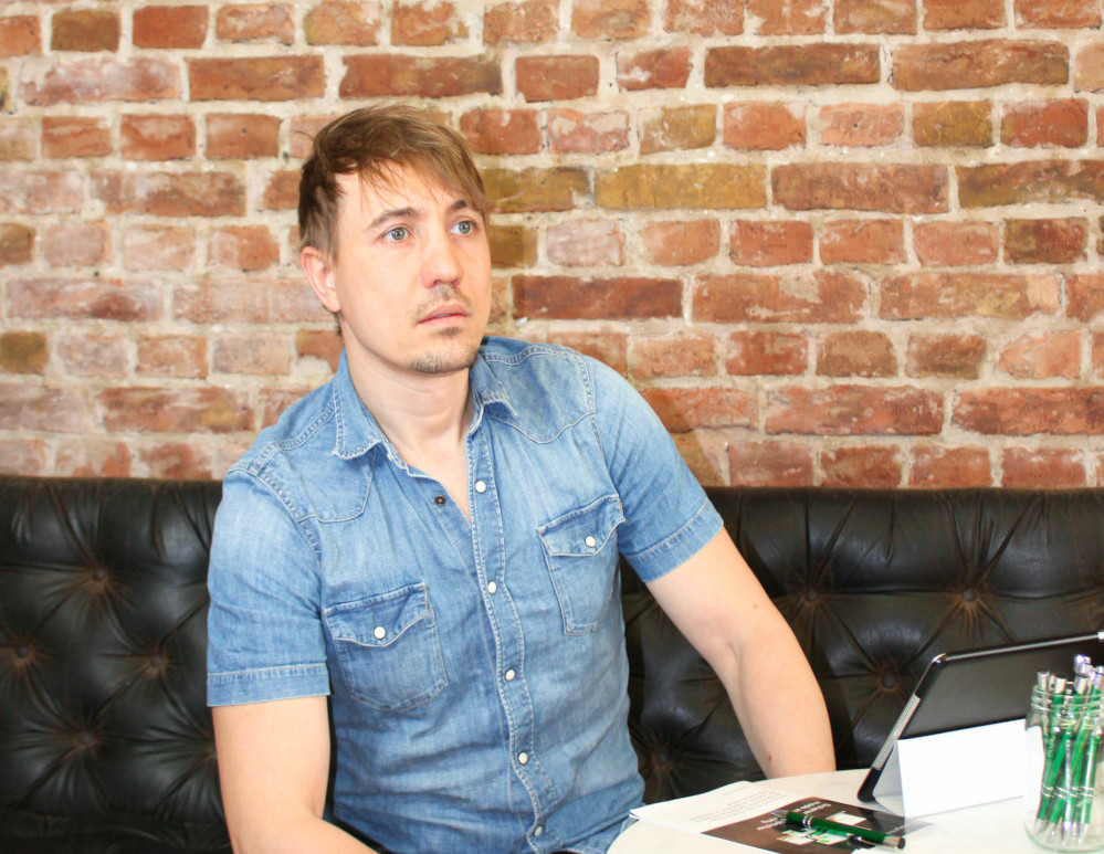 Luc Mader, the founder of luckycloud, is sitting in front of a tablet on a sofa.